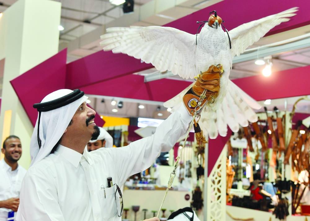 An enthusiast holds up a falcon at the exhibition.