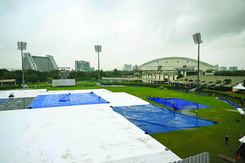 Groundsmen remove the covers after the one-off Test between Afghanistan and New Zealand was called off at the Shaheed Vijay Singh Pathik Sports Complex in Greater Noida on Friday. (AFP)