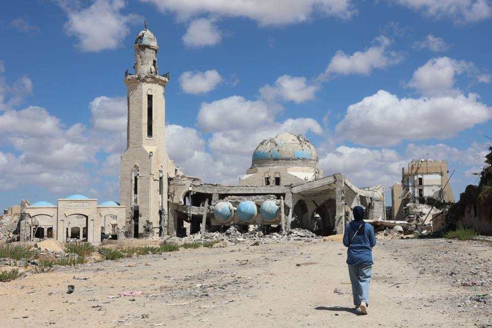 A Palestinian woman walks toward a mosque, heavily damaged in Israeli bombing, in Beit Lahia in the northern Gaza Strip on Saturday. AFP