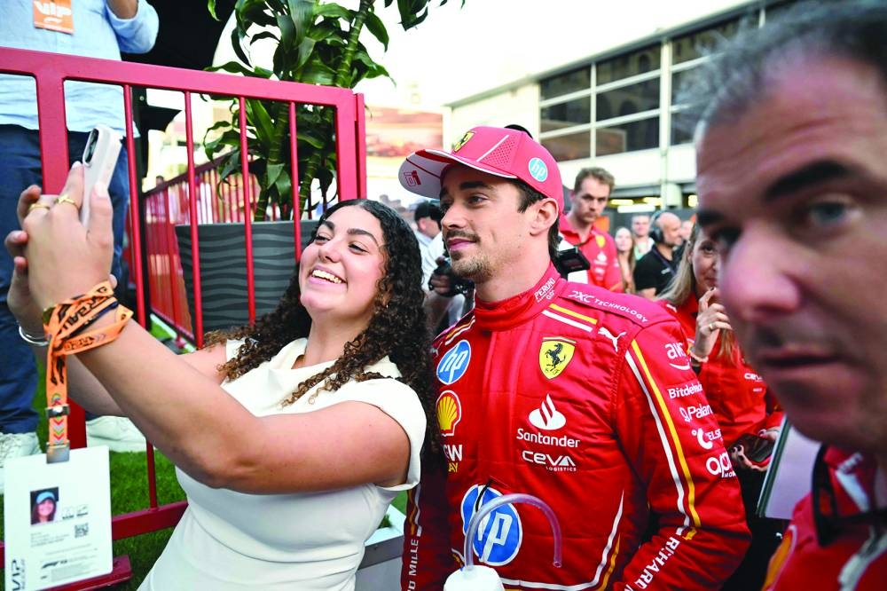 Ferrari’s Monegasque driver Charles Leclerc poses for pictures with a fan after the qualifying session ahead of the Azerbaijan Grand Prix at the Baku City Circuit in Baku on Saturday. (AFP)