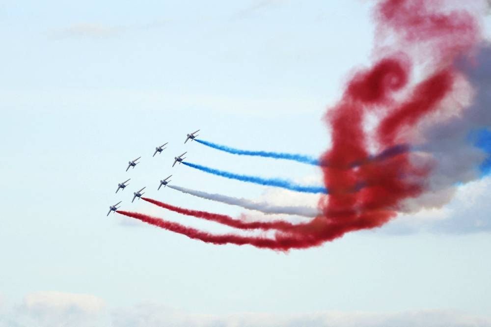 French Air Force Elite acrobatic flying team "Patrouille de France" performs as French athletes who competed in the Paris 2024 Olympic and Paralympic Games parade on the Champs-Elysees avenue in Paris on Saturday. AFP