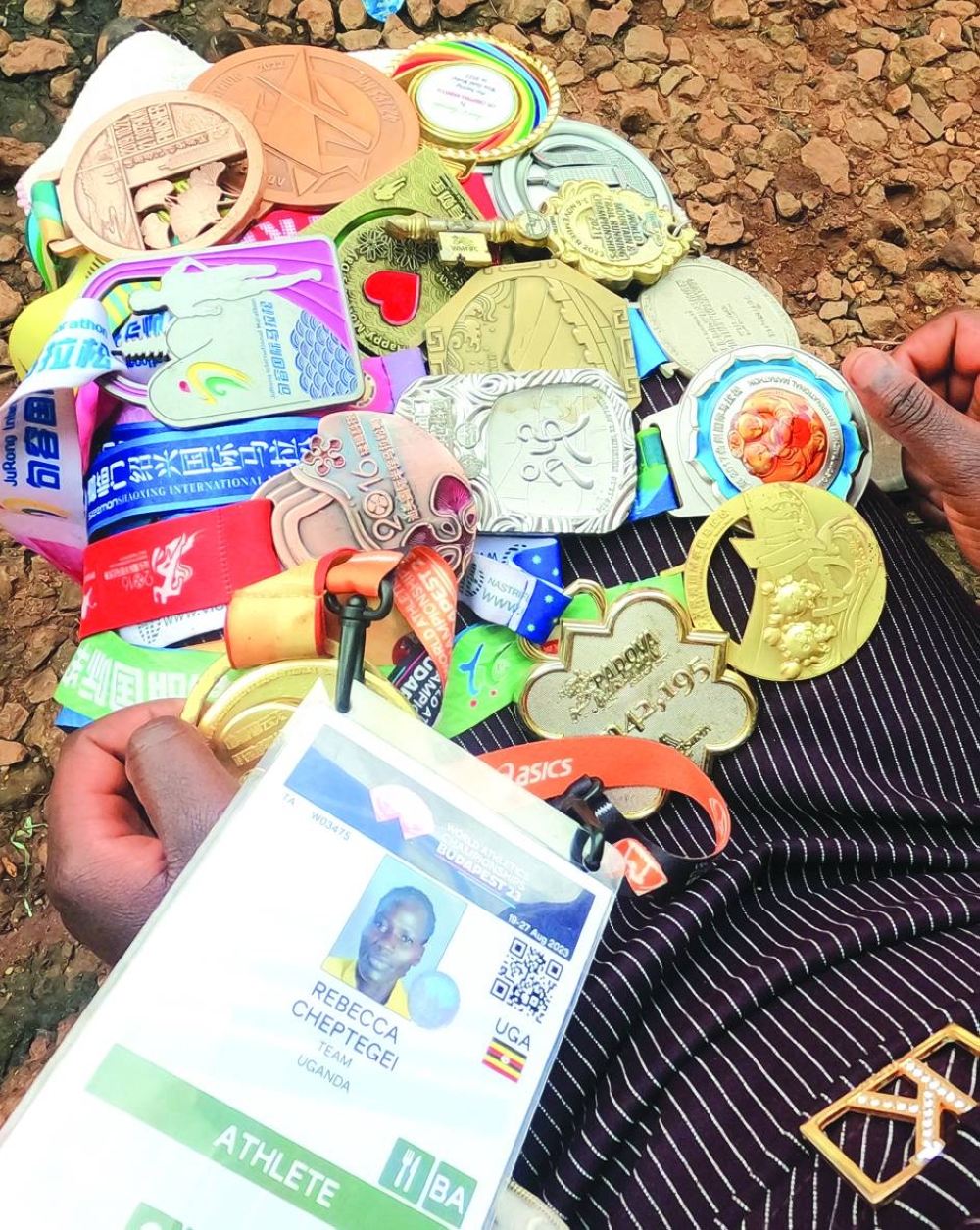 
Right: Dorcas Cheptegei, sister of the Ugandan slain Olympian, holds Rebecca’s athletics medals at their home in Kitum village near Endebess, within Trans-Nzoia County, Kenya. – Reuters 