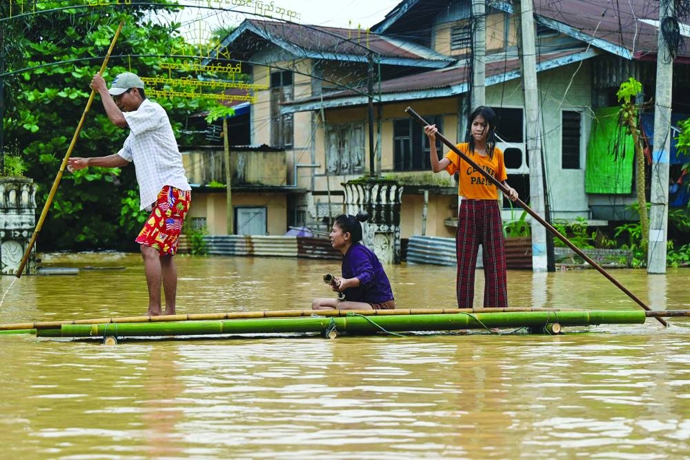 
Flood-affected residents ride a bamboo raft in Taungoo. 