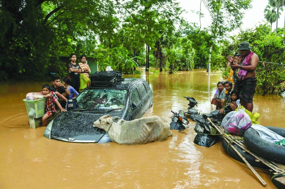 Flood-affected residents wait for a rescue boat to arrive in Taungoo, Myanmar’s Bago region on Saturday.