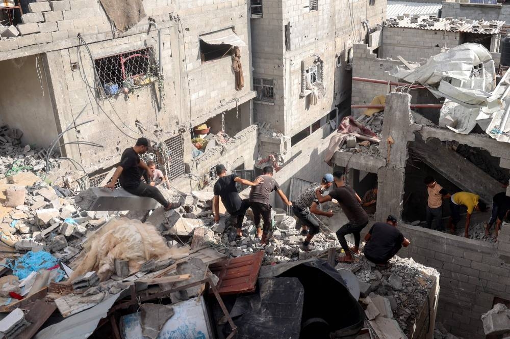 Palestinians check the rubble of a house following Israeli bombardment in Nuseirat in the central Gaza Strip on Monday. AFP