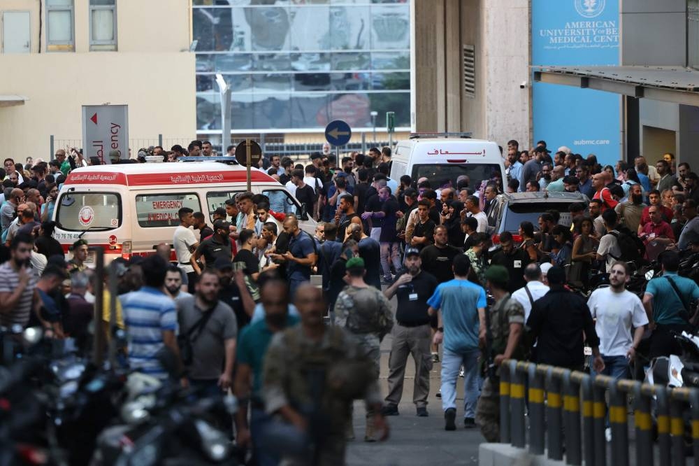 Ambulances are surrounded by people at the entrance of the American University of Beirut Medical Center, on Tuesday, after explosions hit locations in several Hezbollah strongholds around Lebanon. AFP