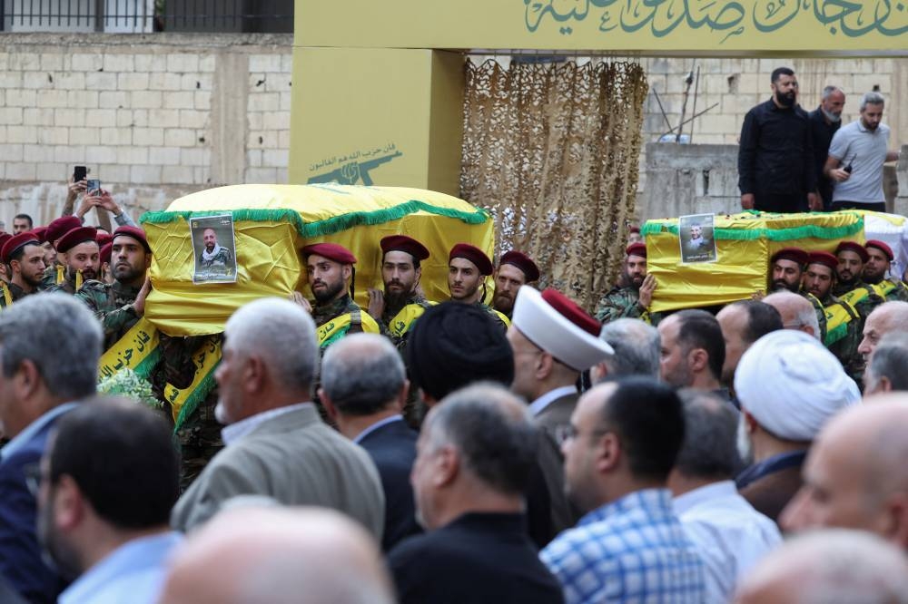 Men carry the coffin of Mohammad Mahdi Ammar, son of Hezbollah member of the Lebanese parliament Ali Ammar, and the coffin of Abbas Fadel Yassin, who were killed amid the detonation of pagers across Lebanon, during their funeral in Beirut, Lebanon on Wednesday. REUTERS