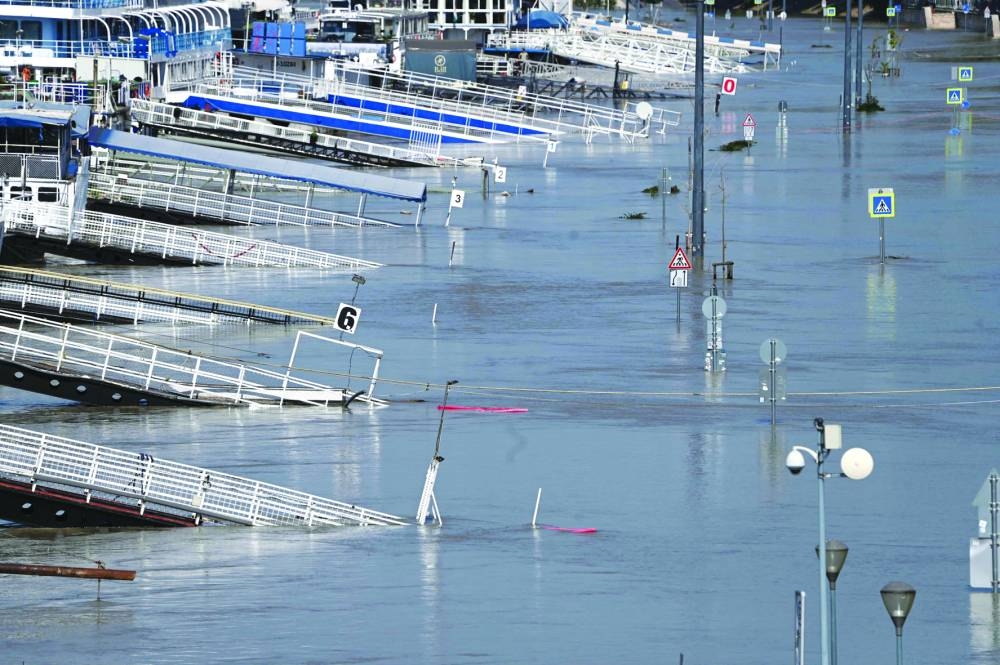 
The piers of tourist boats and traffic signs are partially submerged in the floodwater of the Danube river in Budapest. – AFP 