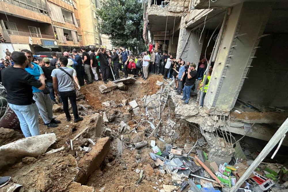 People check the damage at the site of an Israeli strike in Beirut's southern suburbs on Friday. AFP