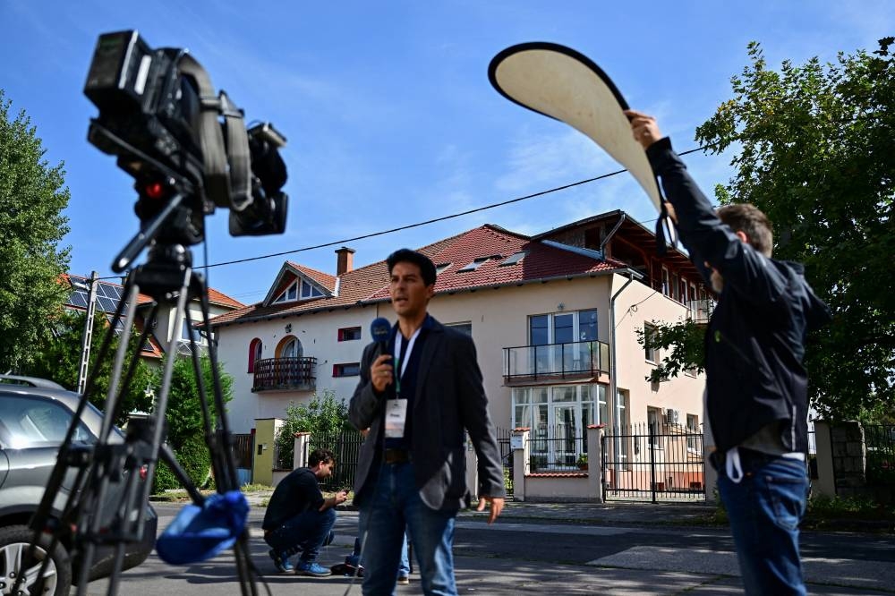 A TV crew operates in front of the office building where BAC Consulting KFT is said to be registered, in Budapest, Hungary, on Wednesday. REUTERS