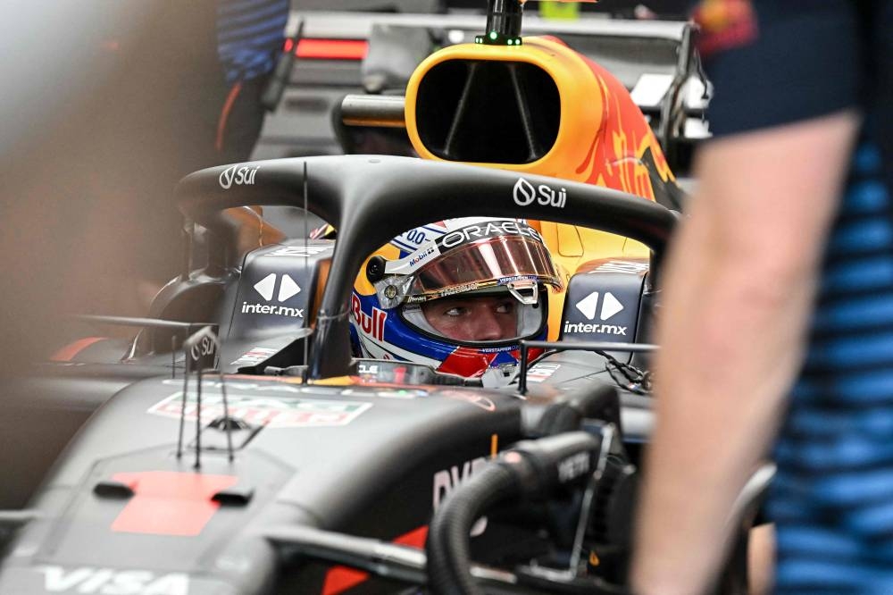 Team mechanics work on the car of Red Bull Racing's Dutch driver Max Verstappen during the first practice session ahead of the Formula One Singapore Grand Prix night race at the Marina Bay Street Circuit in Singapore on Friday (AFP)