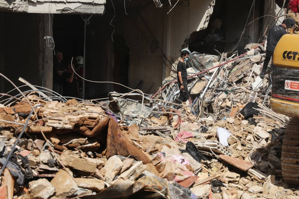 Debris covers the ground near a damaged building at the site of Friday's Israeli strike, as search and rescue operations continue, in Beirut's southern suburbs, Lebanon on Saturday. REUTERS
