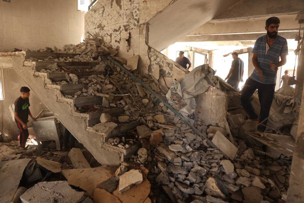 Palestinians inspect the damage at the site of an Israeli strike on a school housing displaced Palestinians in Gaza City's Zaytoun neighbourhood, on Saturday. AFP