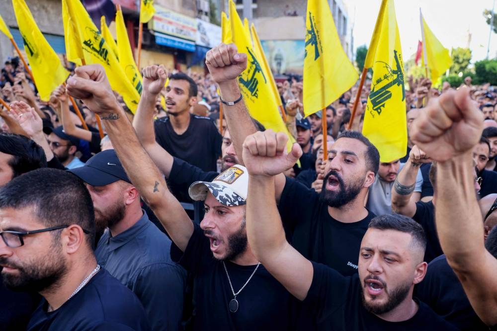 Mourners attend the funeral of members of Hezbollah who were killed in an Israeli strike on Friday, in the southern suburb of Beirut Saturday.