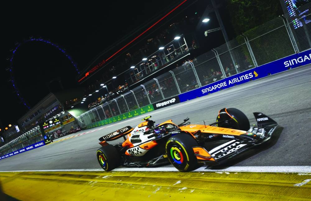 
McLaren’s Lando Norris (also inset) in action during the Singapore Grand Prix at Marina Bay Street Circuit, Singapore, yesterday. Norris posted his third win of the season by clinching the race in Singapore. (Reuters) 