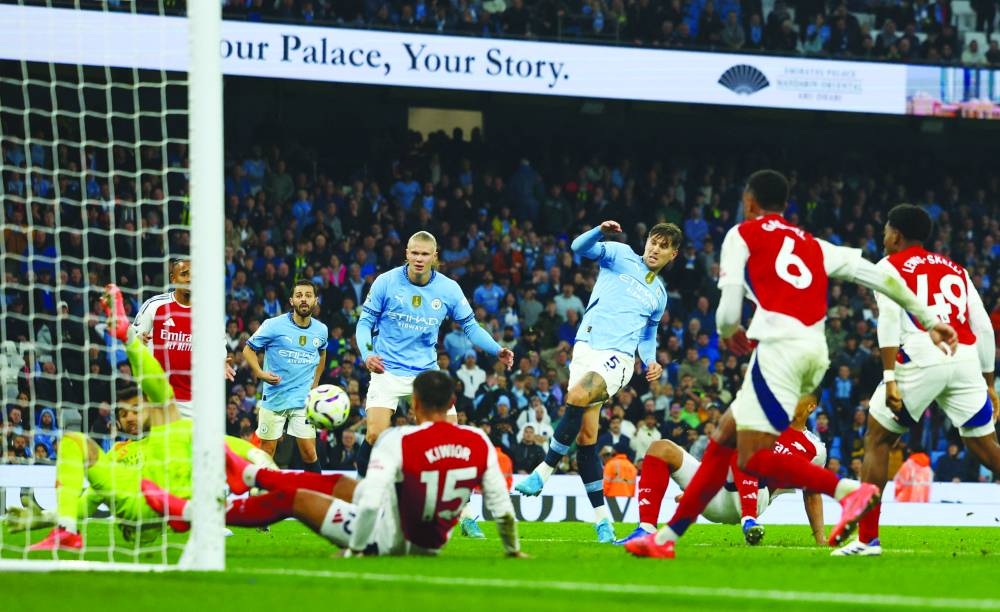 Manchester City’s John Stones (centre) scores against Arsenal during the Premier League match yesterday. (Reuters)