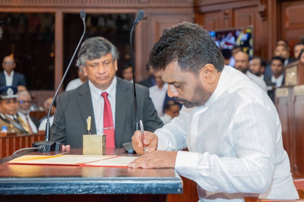 Sri Lanka's newly elected President Anura Kumara Dissanayake signs his oath document of office during the swearing-in ceremony at the Presidential Secretariat, in Colombo, Sri Lanka, Monday. Sri Lanka President Media/Handout via REUTERS