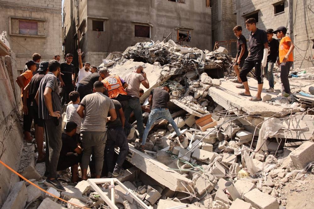 Palestinians search for survivors amid the rubble of a building, which collapsed after Israeli bombardment on a building adjacent to it, in the Sheikh Radwan neighbourhood in Gaza City, on Monday. AFP