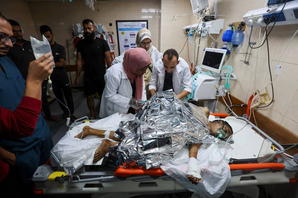 Medics treat a Palestinian boy, who was wounded in an Israeli strike at Al-Aqsa Martyrs Hospital in Deir Al-Balah in the central Gaza Strip, on Monday. REUTERS