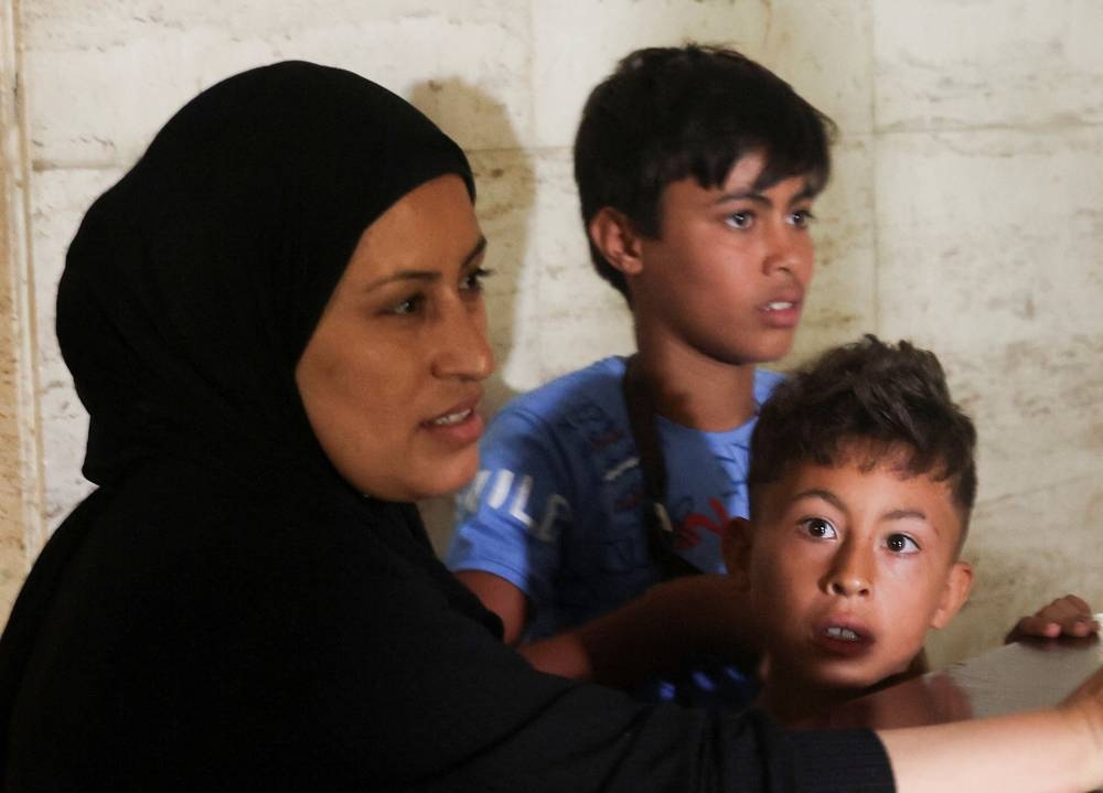 Internally displaced boy who fled from southern Lebanon village reacts at the entrance of a makeshift shelter in Dekwaneh, Lebanon on Monday. REUTERS