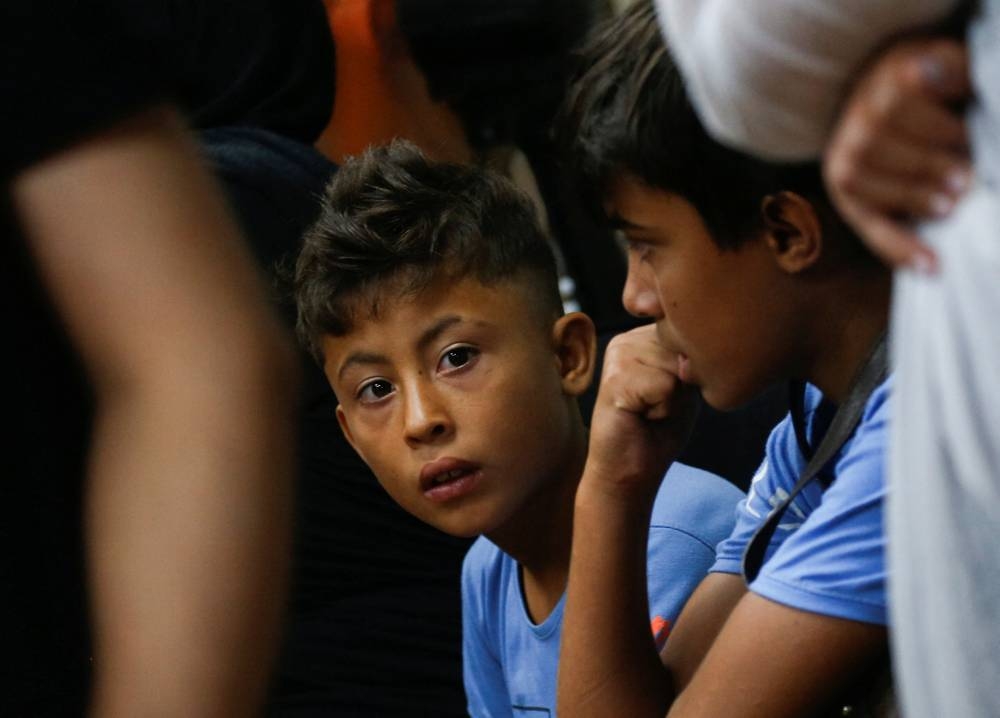 Internally displaced boys who fled with their family from southern Lebanon villages react at a makeshift shelter in Dekwaneh, Lebanon on Monday. REUTERS