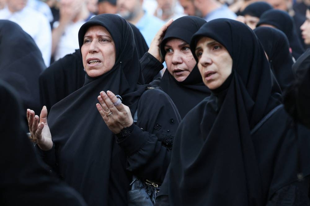 Mourners attend the funeral of Mohammad Surur, head of one of Hezbollah's air force units who was killed in Israel's strike on Beirut's southern suburbs on Thursday, and two Hezbollah members Hussein Aweleh and Khodr Atwi, in Beirut's southern suburbs, Lebanon, on Friday. REUTERS