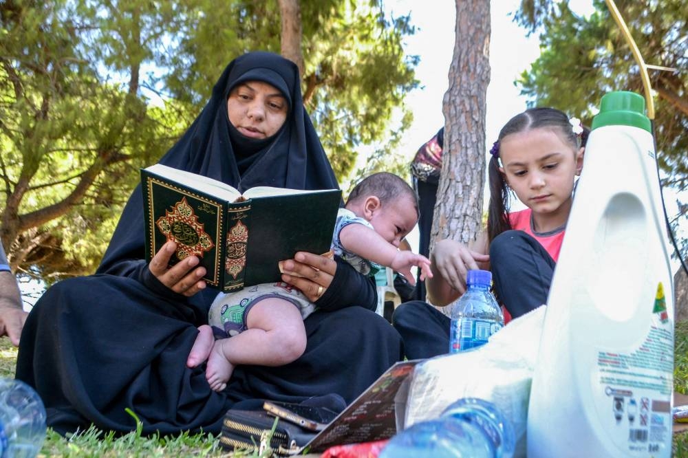 Displaced families who fled Israeli strikes in southern Lebanon are pictured at a park where they are taking refuge in Tripoli, on Friday. AFP