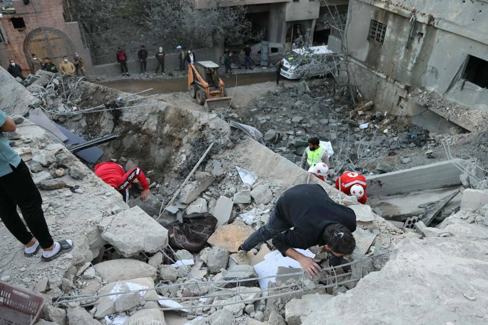 Rescuers check the rubble of a building following an overnight Israeli airstrike in the southern Lebanese village of Shebaa near along the border between the two countries, on Friday. AFP