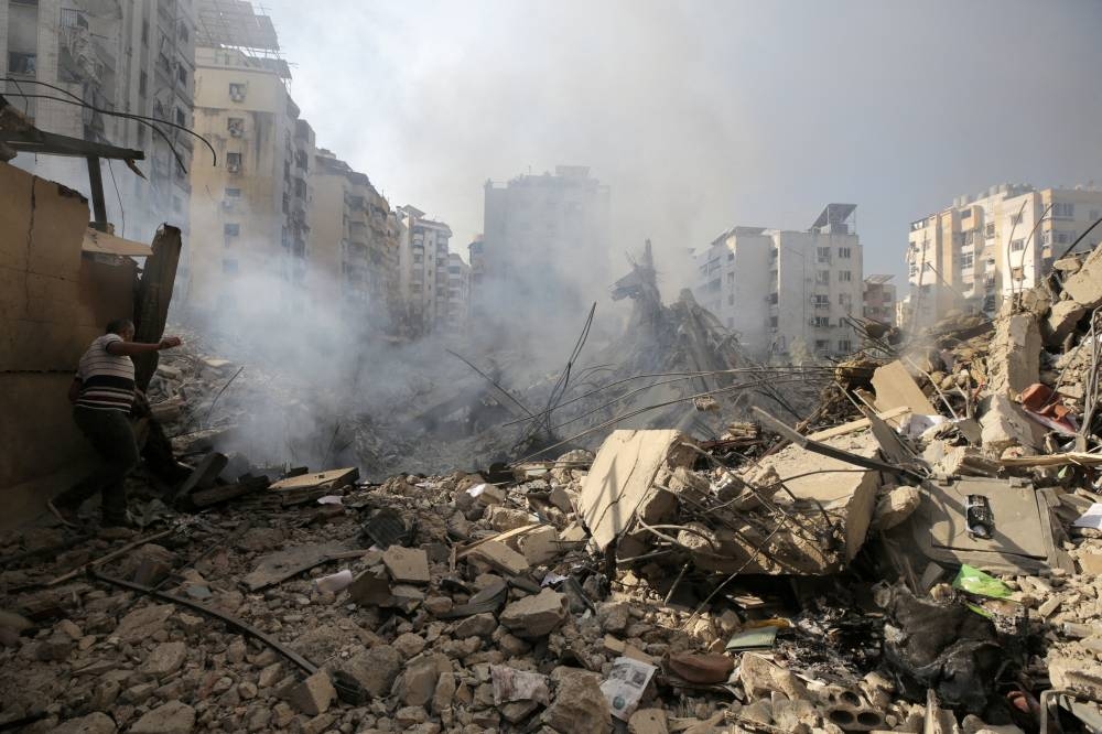 A man walks on the rubble of damaged buildings in the aftermath of Israeli air strikes on Beirut's southern suburbs, Lebanon on Saturday. REUTERS
