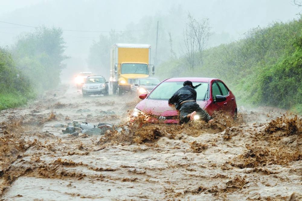 
A local resident helps free a car that became stranded in a stretch of flooding road as Tropical Storm Helene strikes, on the outskirts of Boone, North Carolina. – Reuters 