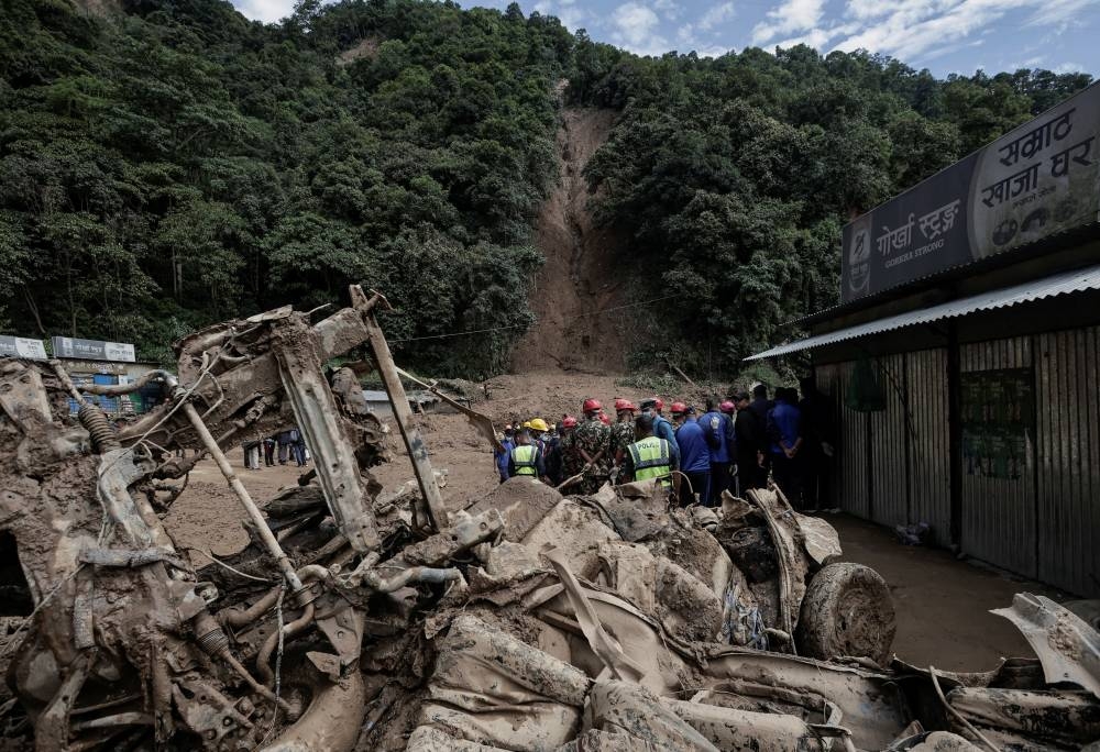 The debris of a passenger bus is pictured in an area where a landslide triggered by heavy rainfall struck passenger vehicles passing by the Tribhuwan Highway in Dhading, Nepal, on Sunday. REUTERS