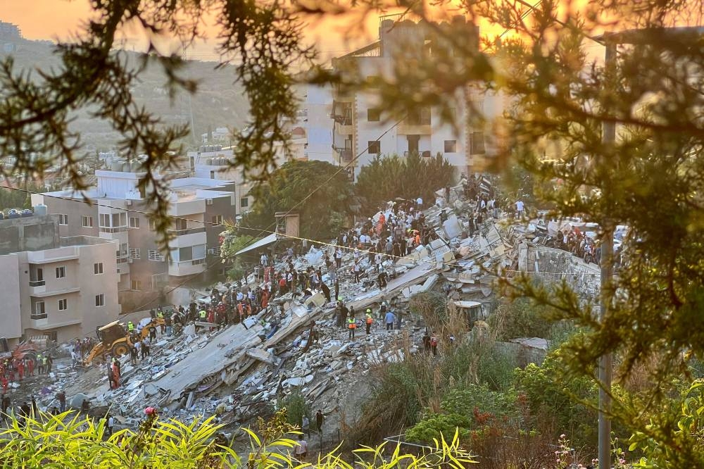 First responders inspect the rubble of a building after it was targeted by an Israeli airstrike in the southern Lebanese village of Ain El Delb on Sunday. AFP