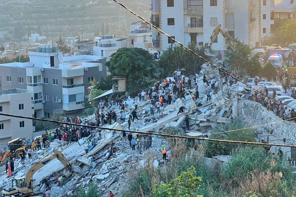 First responders inspect the rubble of a building after it was targeted by an Israeli airstrike in the southern Lebanese village of Ain El Delb Sunday.