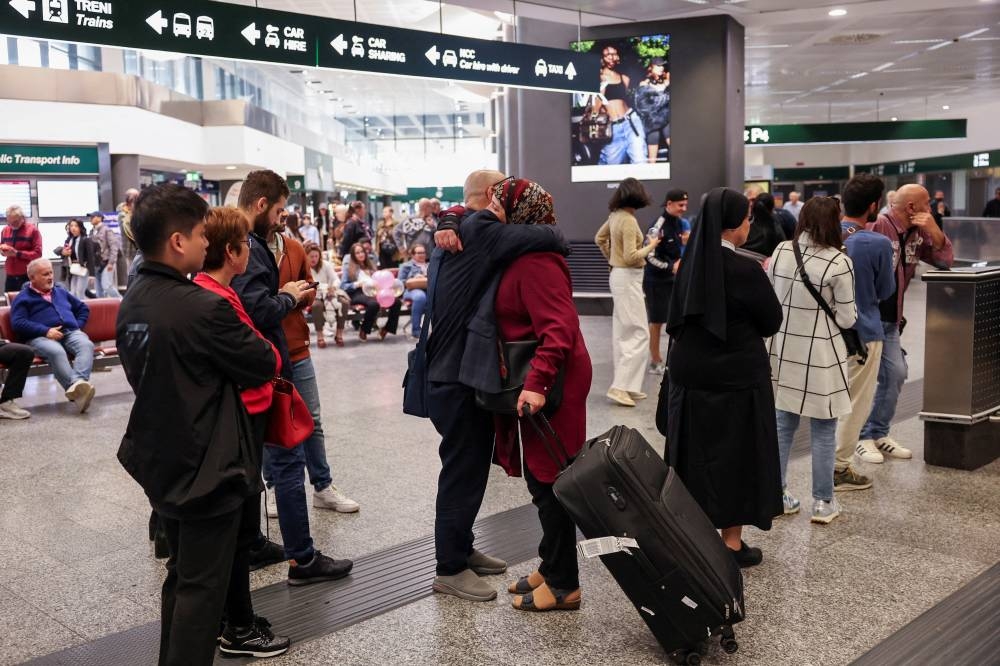 A passenger arriving from Beirut, amid the ongoing hostilities between Hezbollah and Israeli forces, hugs a person inside the arrival terminal of Malpensa airport in Milan, Italy, on Monday. REUTERS