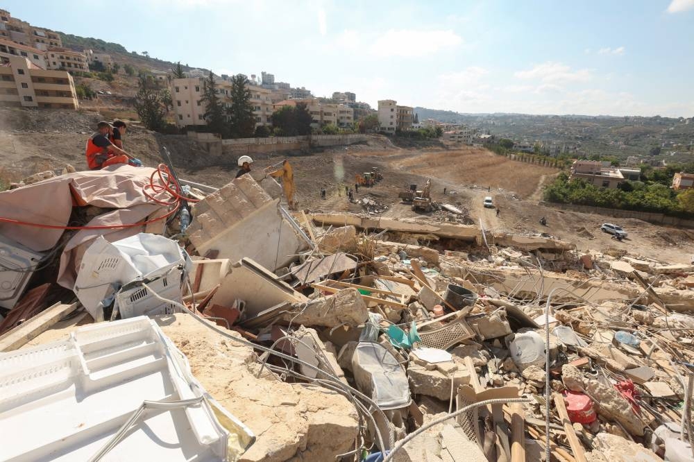 Rescuers work at the site of Sunday's Israeli attack on the city of Ain Deleb, amid the ongoing hostilities between Hezbollah and Israeli forces, in southern Lebanon, on Monday. REUTERS