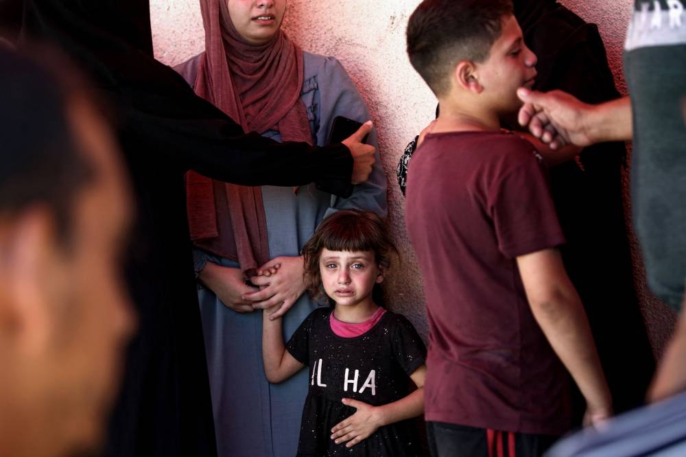Palestinians mourn the death of a relative killed in Israeli strikes on Al-Bureij refugee camp, at the Al-Aqsa Martyrs hospital in Deir el-Balah in the central Gaza Strip on Monday. AFP