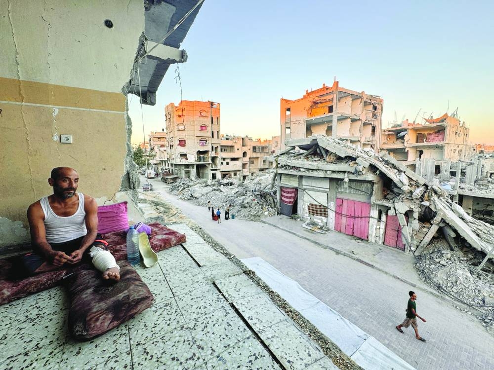 A Palestinian rests near rubble of houses destroyed in Israeli strikes, in Khan Younis in the southern Gaza Strip, Monday.