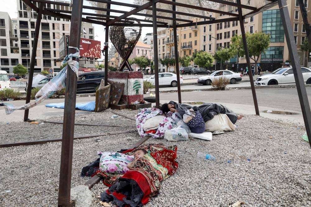 Displaced children sleep on the side walk in downtown Beirut, on Tuesday. AFP