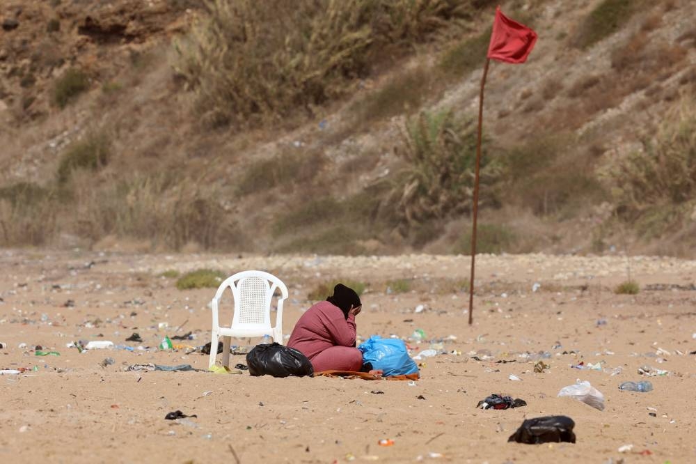 A displaced woman sits at Beirut’s Ramleit al Baida beach turned into a makeshift refugee camp, on Tuesday. AFP