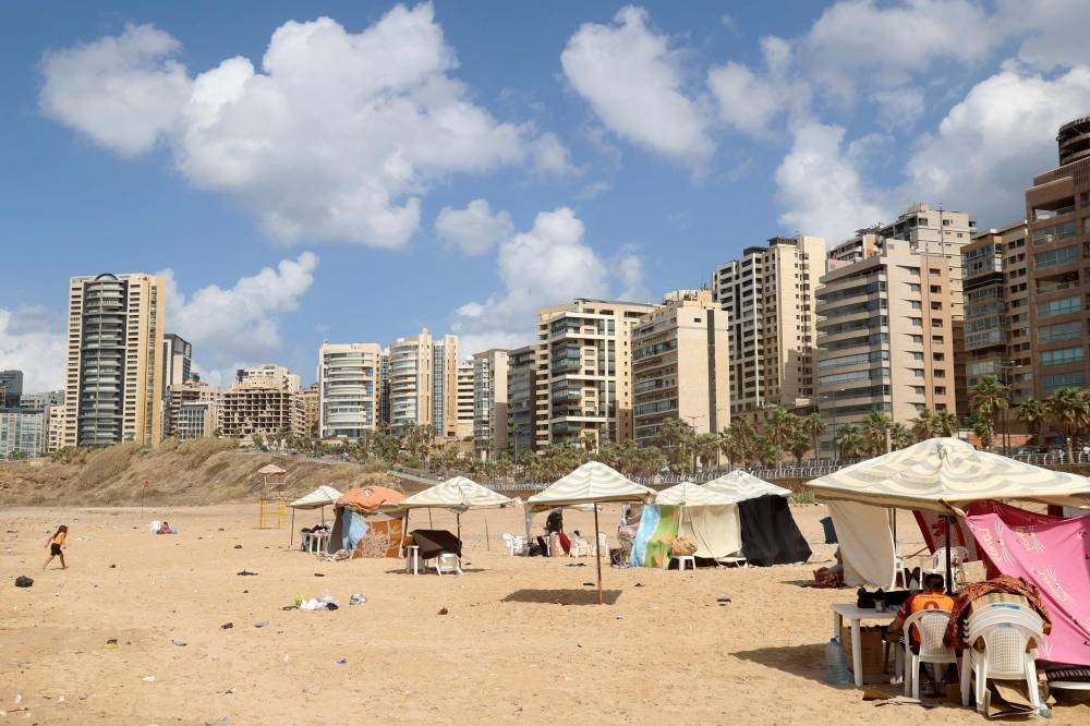 Displaced people gather on Beirut’s Ramleit al Baida beach turned into a makeshift refugee camp, on Tuesday. AFP