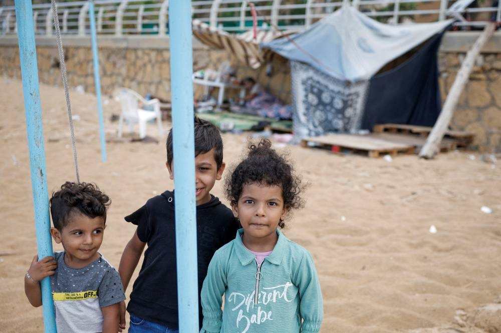 Displaced children pose at a makeshift encampment where scores of displaced people live at a beach in Beirut, Lebanon, on Tuesday. REUTERS