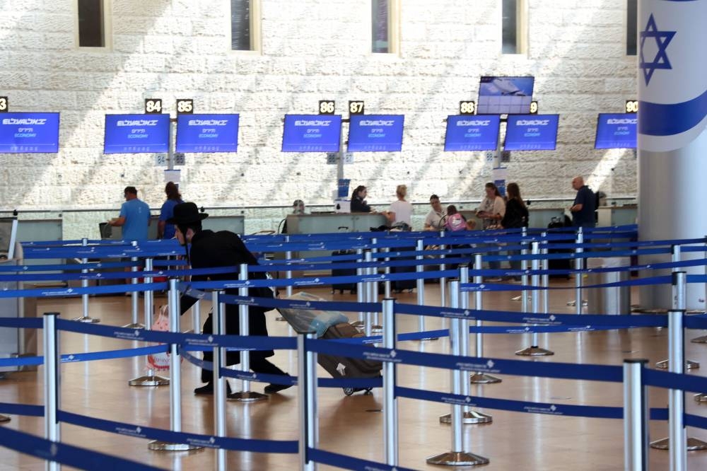 A passenger drags his suitcase at the departure lounge of the Ben Gurion Airport in Tel Aviv on Sunday, amid cross-border clashes with the Hezbollah and Israel. AFP