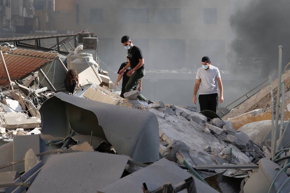 People look at the damage in the aftermath of Israeli strikes in Chiyah, Lebanon, on Wednesday. REUTERS