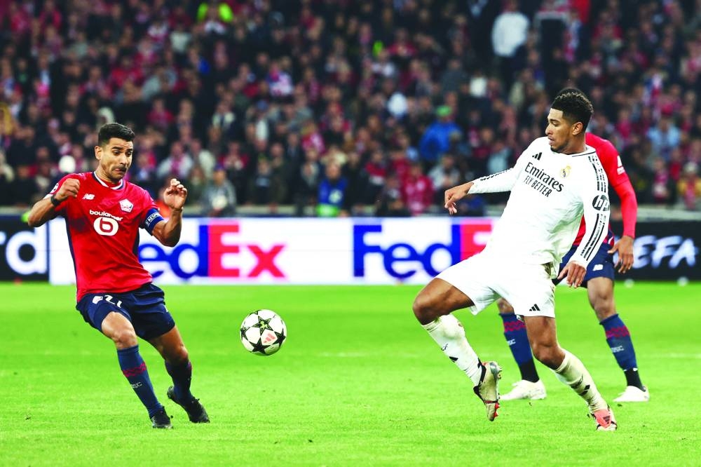 Real Madrid’s English midfielder Jude Bellingham (right) fights for the ball with Lille’s French midfielder Benjamin Andre during the UEFA Champions League match at the Pierre Mauroy Stadium in Villeneuve-d’Ascq, northern France, on Wednesday. (AFP)