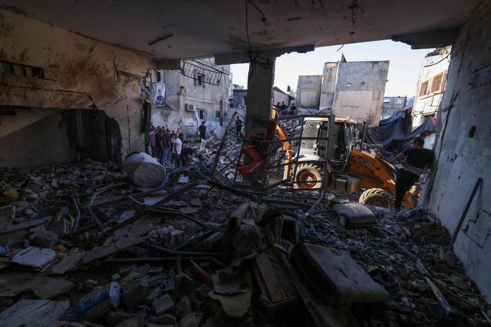 Palestinians inspect the damage on the site of an overnight Israeli airstrike on the Tulkarem refugee camp in the north of the occupied West Bank, on Friday. AFP