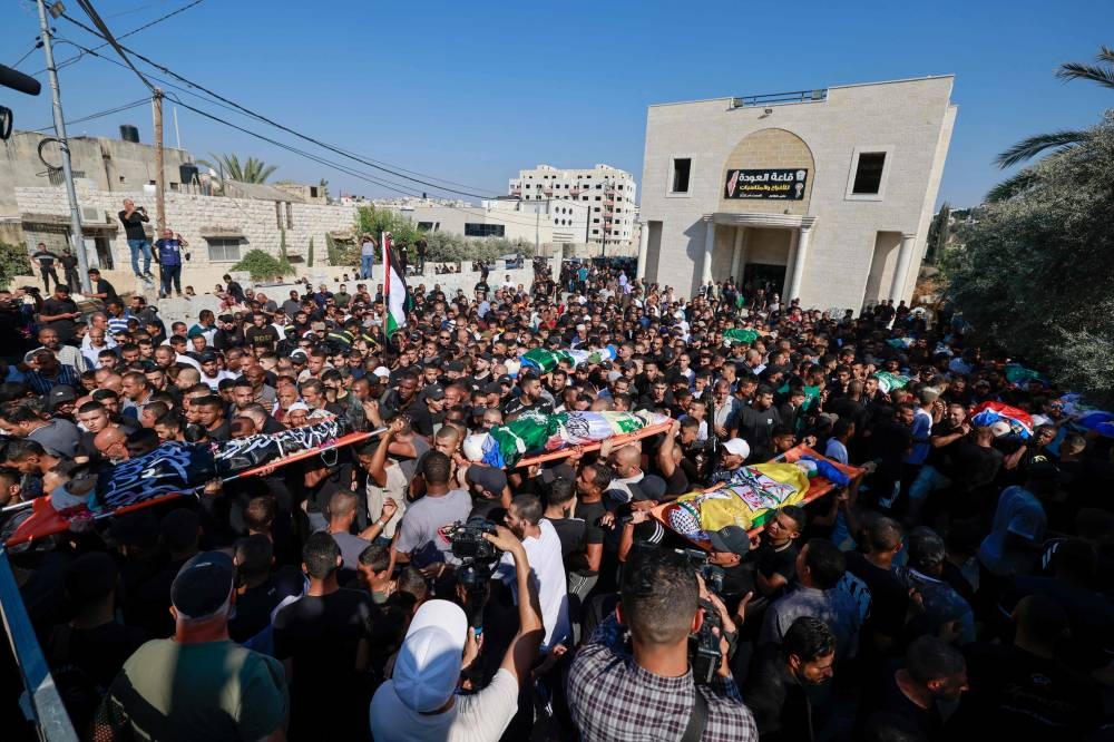 Mourners carry the bodies of Palestinians killed in an Israeli airstrike on the Tulkarem refugee camp the previous night, during their funeral procession at the camp in the occupied West Bank, on Friday. AFP
