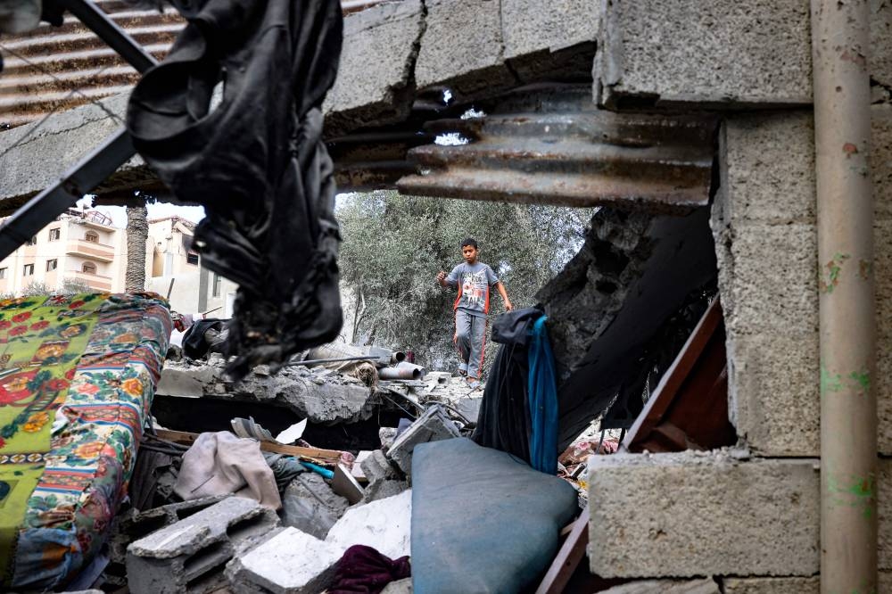 A boy walks amid the rubble of a house hit by an Israeli strike in Deir El-Balah in the central Gaza Strip on Friday. AFP