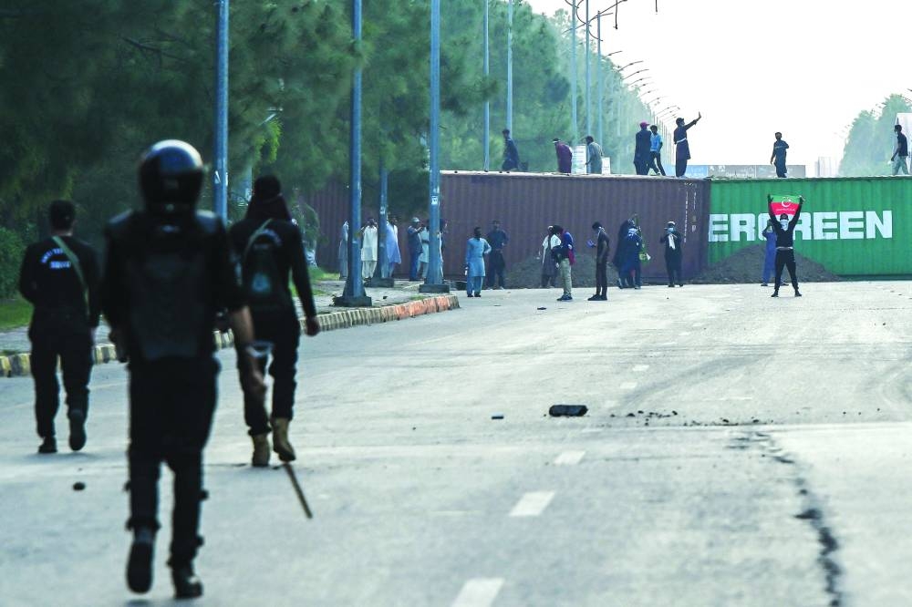 Police personnel are seen on a major road in Islamabad that has been blocked by the authorities using shipping containers. – Reuters