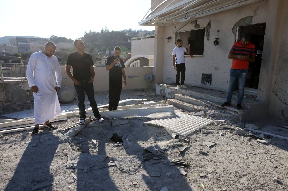 People look at the damage to a home following a rocket attack from Lebanon in Deir al-Asad, northern Israel, on Saturday. REUTERS