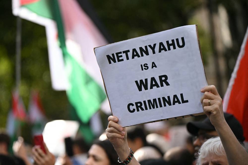 Pro-Palestinian activists and supporters wave flags and hold placards as they pass through central London, during a March for Palestine, on Saturday. AFP